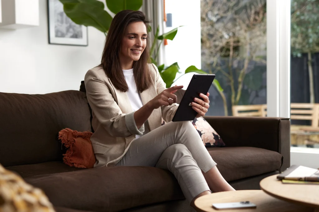 Vrouw op de bank met een tablet in de hand, campagnebeeld voor TomTom