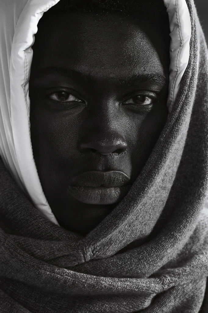 Close-up van een model met witte capuchon en grijze gebreide sjaal, Gogetti editorial in zwart-wit