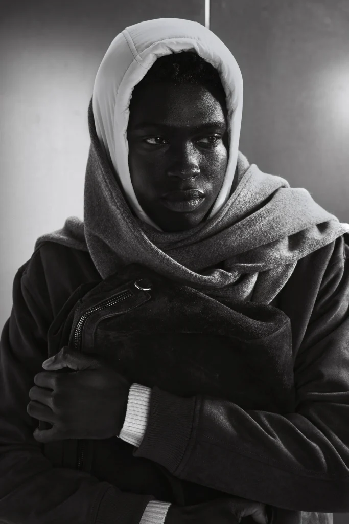 Model met witte capuchon houdt een suede tas tegen zich aan, Gogetti editorial