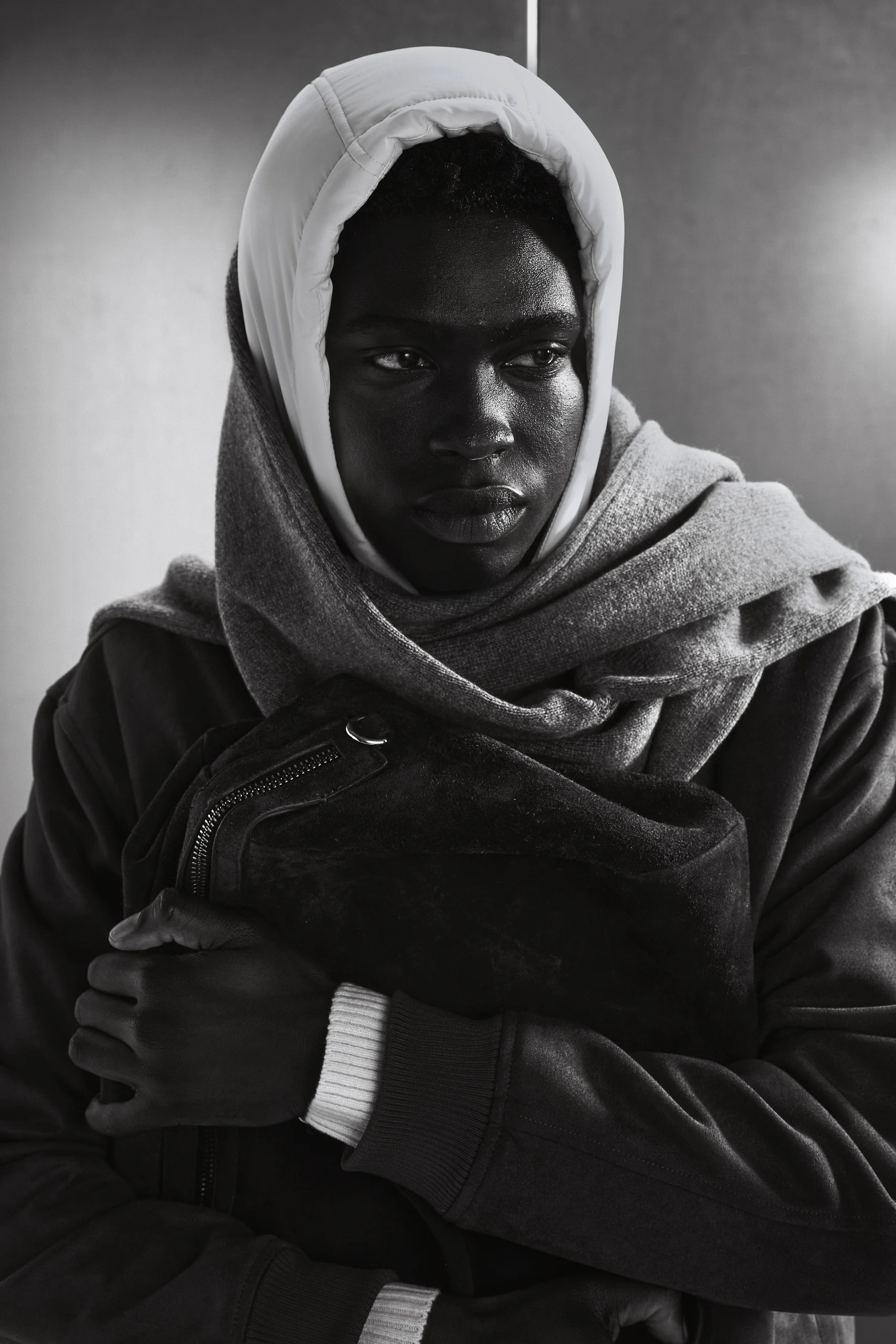 Model met witte capuchon houdt een suede tas tegen zich aan, Gogetti editorial